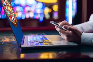 A woman smiling by bright slot machines showing lucky symbols, showcasing the exciting slot offerings at BB444.